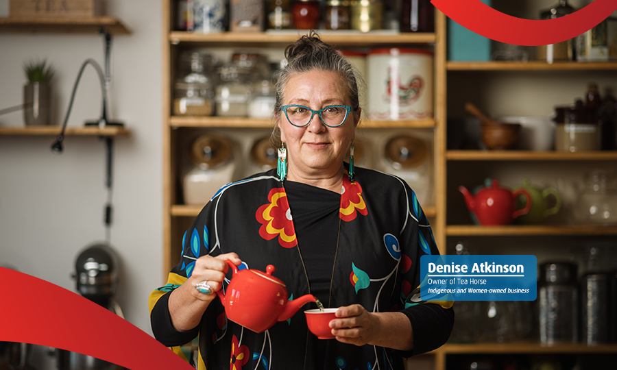 Underrepresented business owner standing in front of a display of her products.